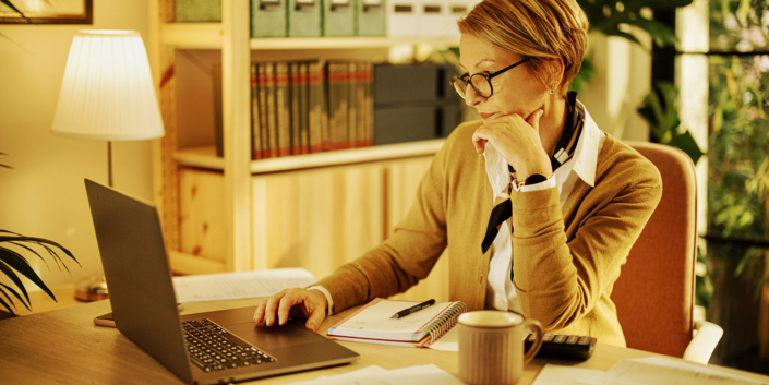 Middle aged businesswoman using laptop while working from home